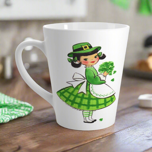 This ceramic glossy latte coffee mug features a midcentury St. Patrick's Day illustration of an adorable girl dresed in green holding a bouquet of shamrocks.