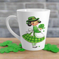 This ceramic glossy latte coffee mug features a midcentury St. Patrick's Day illustration of an adorable girl dresed in green holding a bouquet of shamrocks.