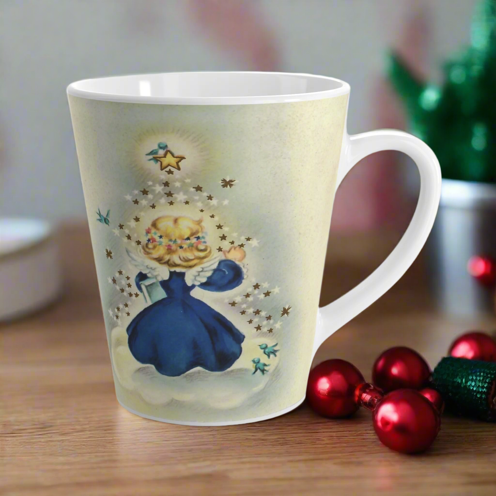 This ceramic glossy latte mug features an angel dressed in blue standing on a cloud. Her back is to us and you can see her wings. She is standing under a yellow star and bluebird. There are smaller white and blue stars and bluebirds surrounding her.