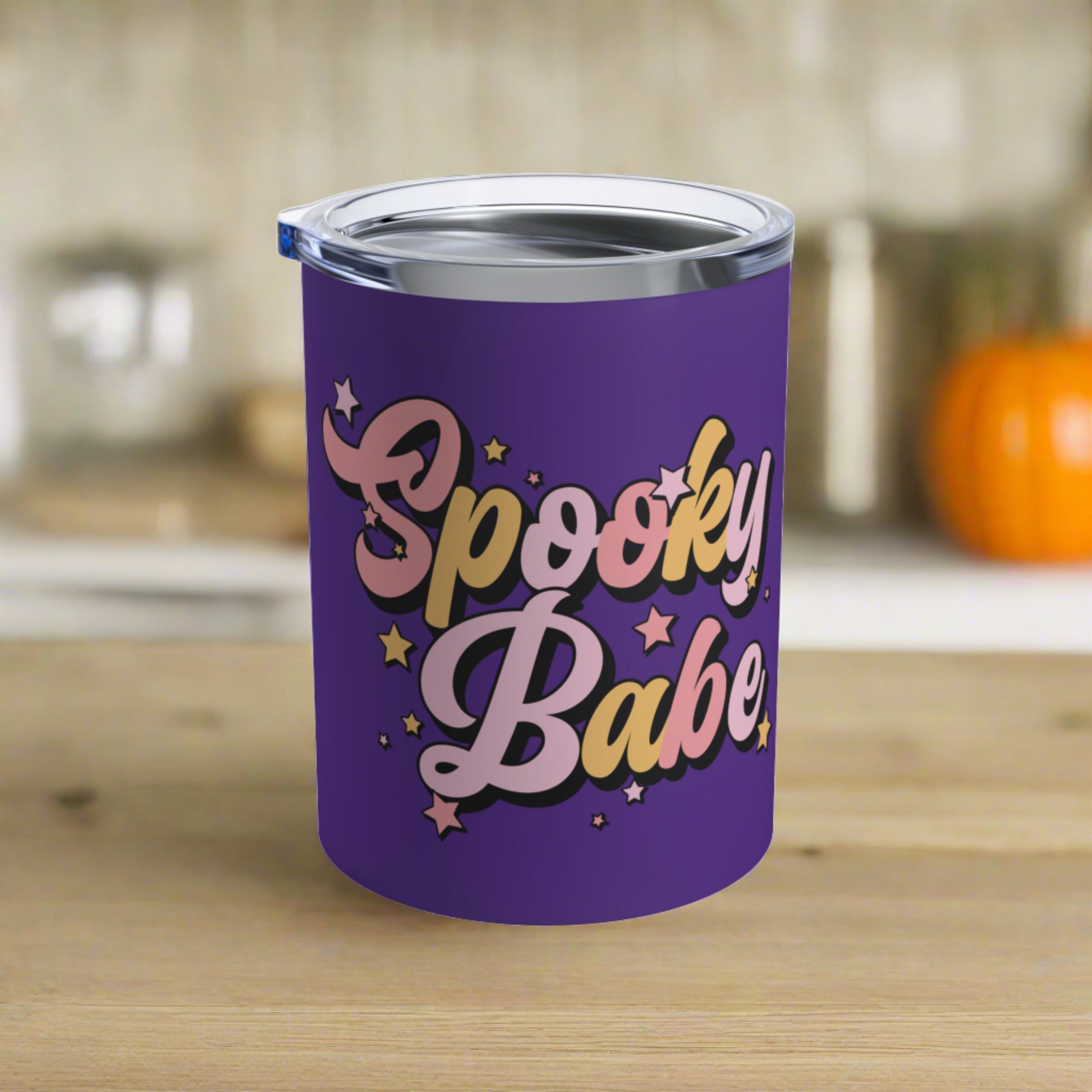 This 10 ounce purple stainless steel travel tumbler mug says Spooky Babe in pinks and yellows with stars.