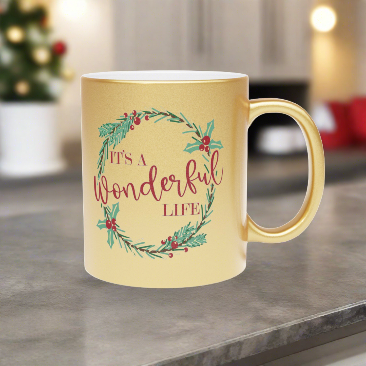 This gold metallic ceramic mug features a holly wreath with red lettering that says It's a Wonderful Life.