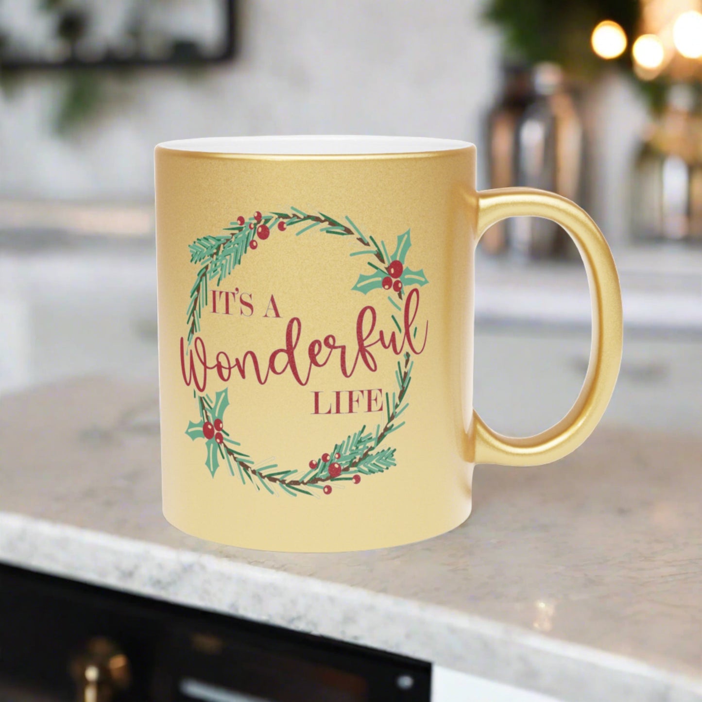 This gold metallic ceramic mug features a holly wreath with red lettering that says It's a Wonderful Life.