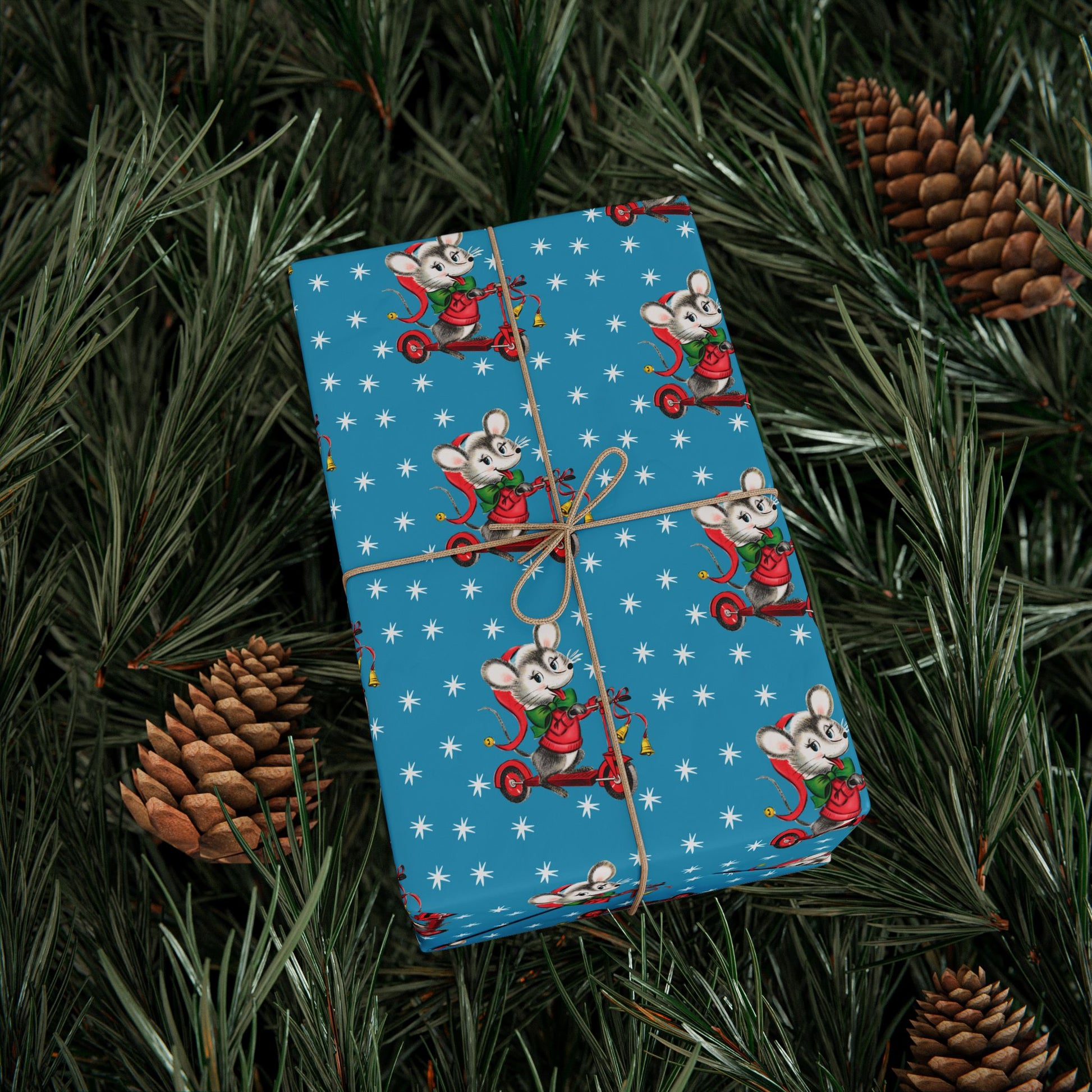 This Christmas gift wrap features a midcentury retro illustration of a cute mouse on a scooter wearing a Santa hat. The background is blue with white stars.