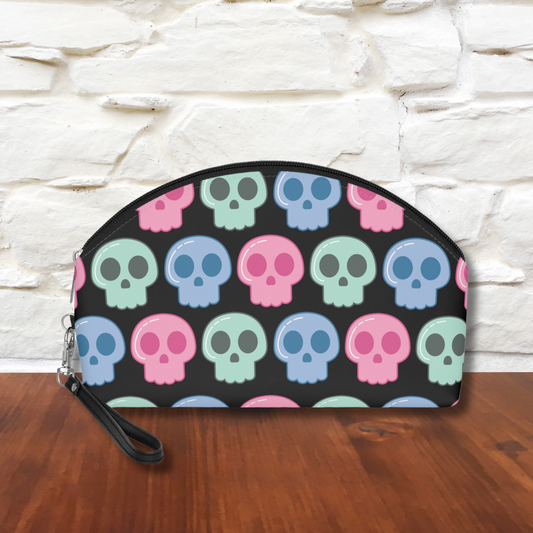 Cute cosmetic makeup travel bag featuring adorable pastel skulls with a black background. The bag has a zipper and a side wristlet.