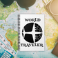 This white spiral journal features a retro print of an airplane and the globe with atomic era lettering that says World Traveler.