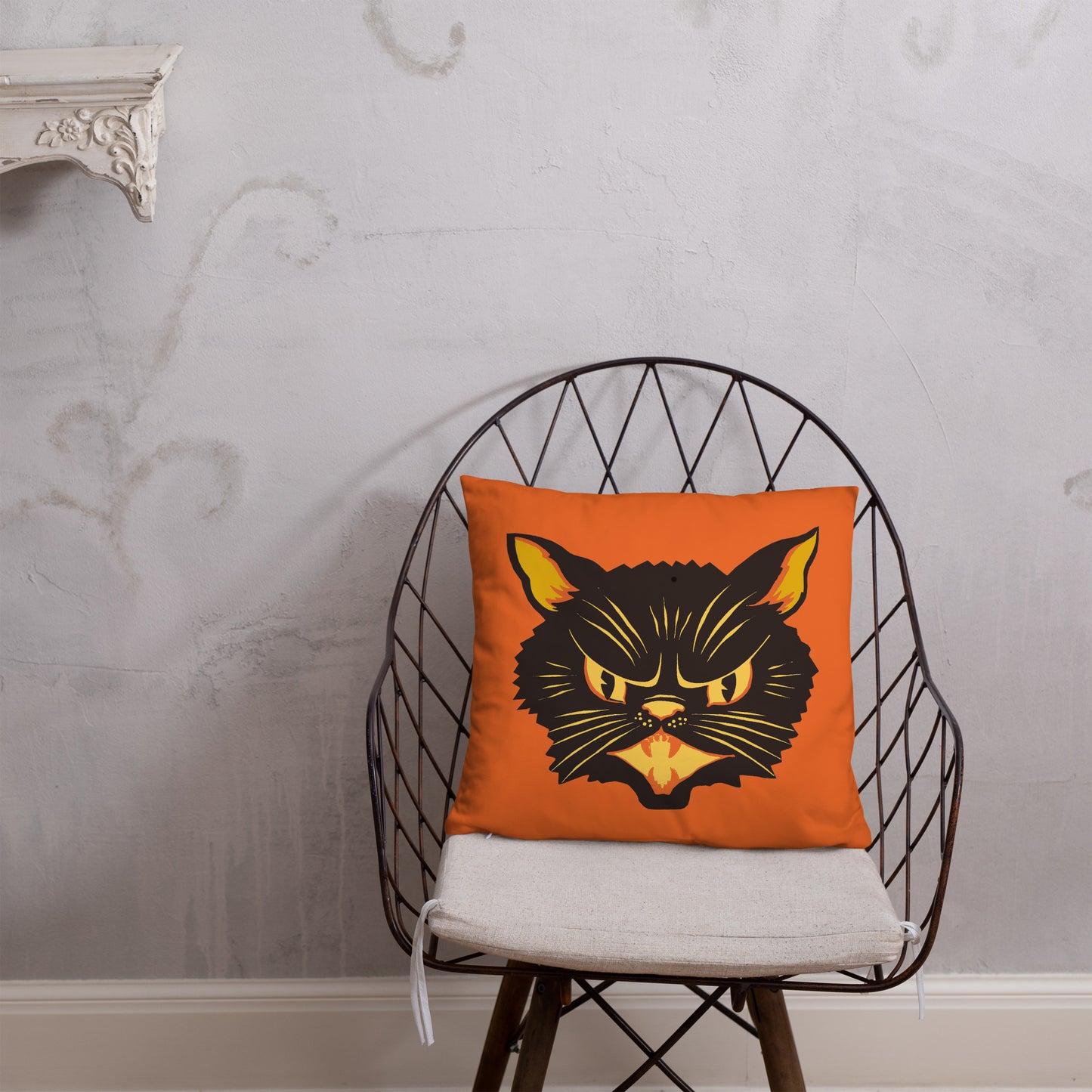 This orange square pillow features a retro midcentury Halloween print of a Black Cat with orange and yellow eyes, ears, nose, whiskers and mouth.