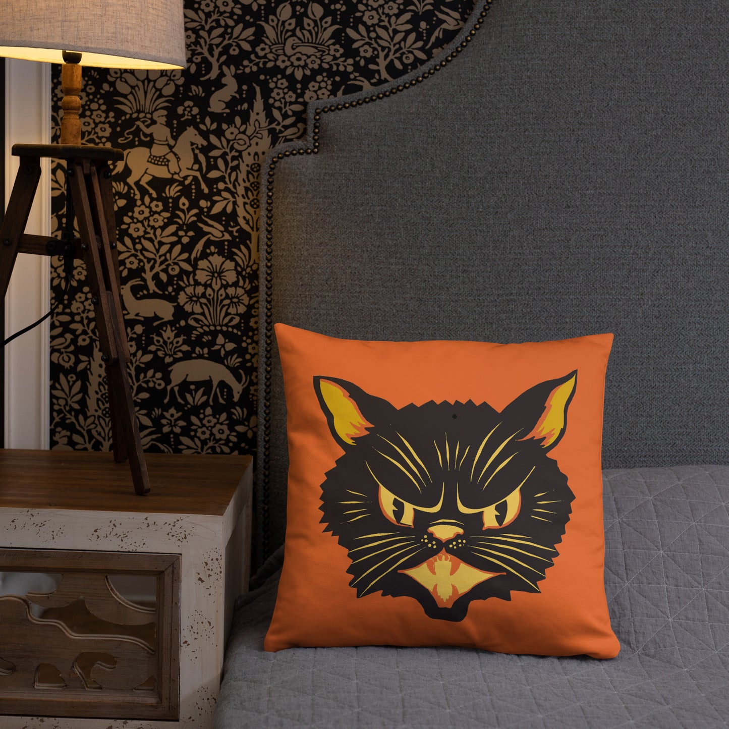 This orange square pillow features a retro midcentury Halloween print of a Black Cat with orange and yellow eyes, ears, nose, whiskers and mouth.