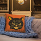 This orange square pillow features a retro midcentury Halloween print of a Black Cat with orange and yellow eyes, ears, nose, whiskers and mouth.