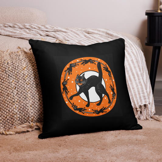 This square black pillow features a vintage Halloween illustration of a black cat with a white full moon and little black cats circling around the moon and stars.