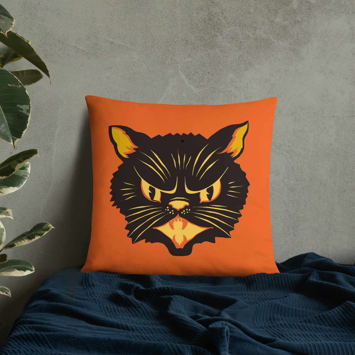 This orange square pillow features a retro midcentury Halloween print of a Black Cat with orange and yellow eyes, ears, nose, whiskers and mouth.