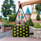 This black crossbody purse features a large red apple dipped in green poison with the words Bite Me underneath and the back is a small size in a patterned print.