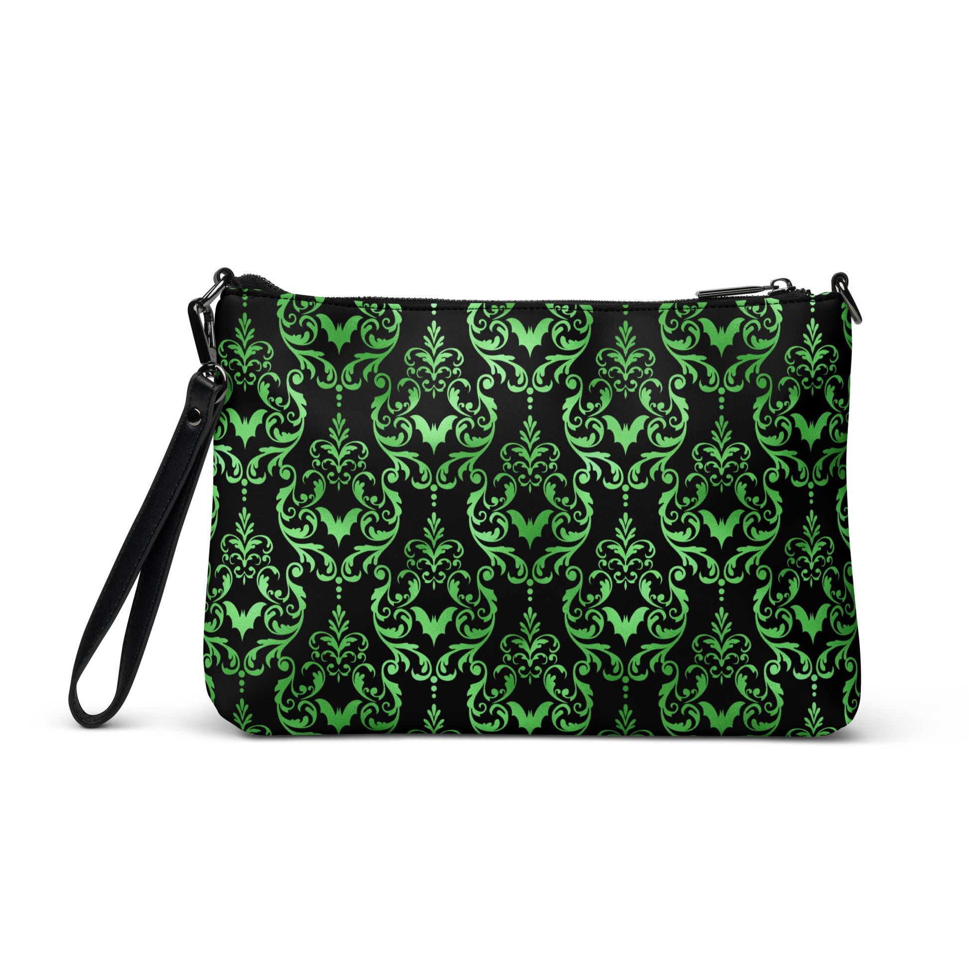 This black crossbody shoulder bag converts into a large wristlet clutch features a retro wallpaper print of green bats and swirls.