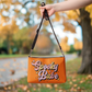 This orange crossbody purse features a retro Barbie style type of lettering that says Spooky Babe in fall pastel colors with stars.