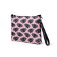 This crossbody shoulder purse converts into a large wristlet clutch. It features adorable grey bats with a pink background.