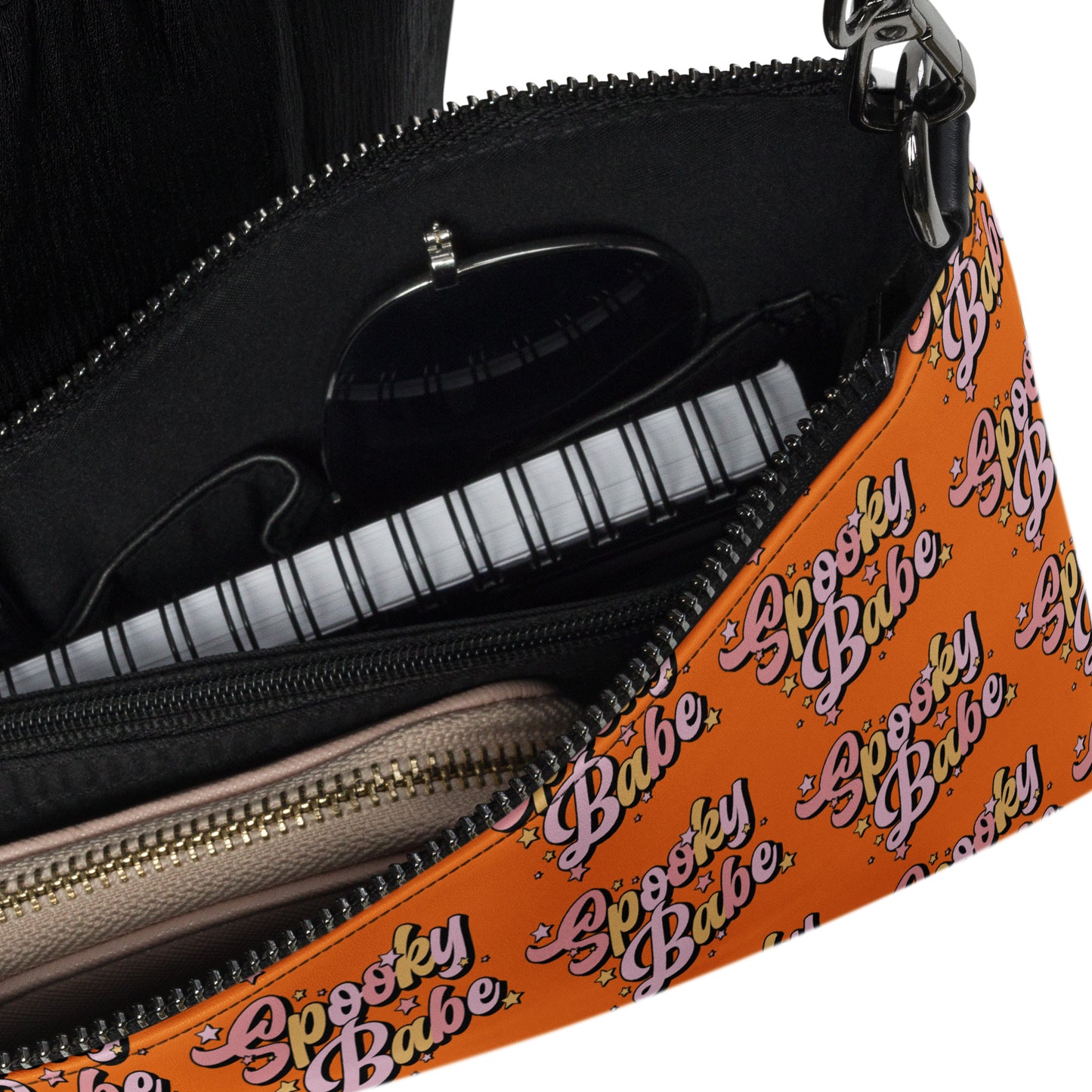 This orange crossbody purse features a retro Barbie style type of lettering that says Spooky Babe in fall pastel colors with stars.