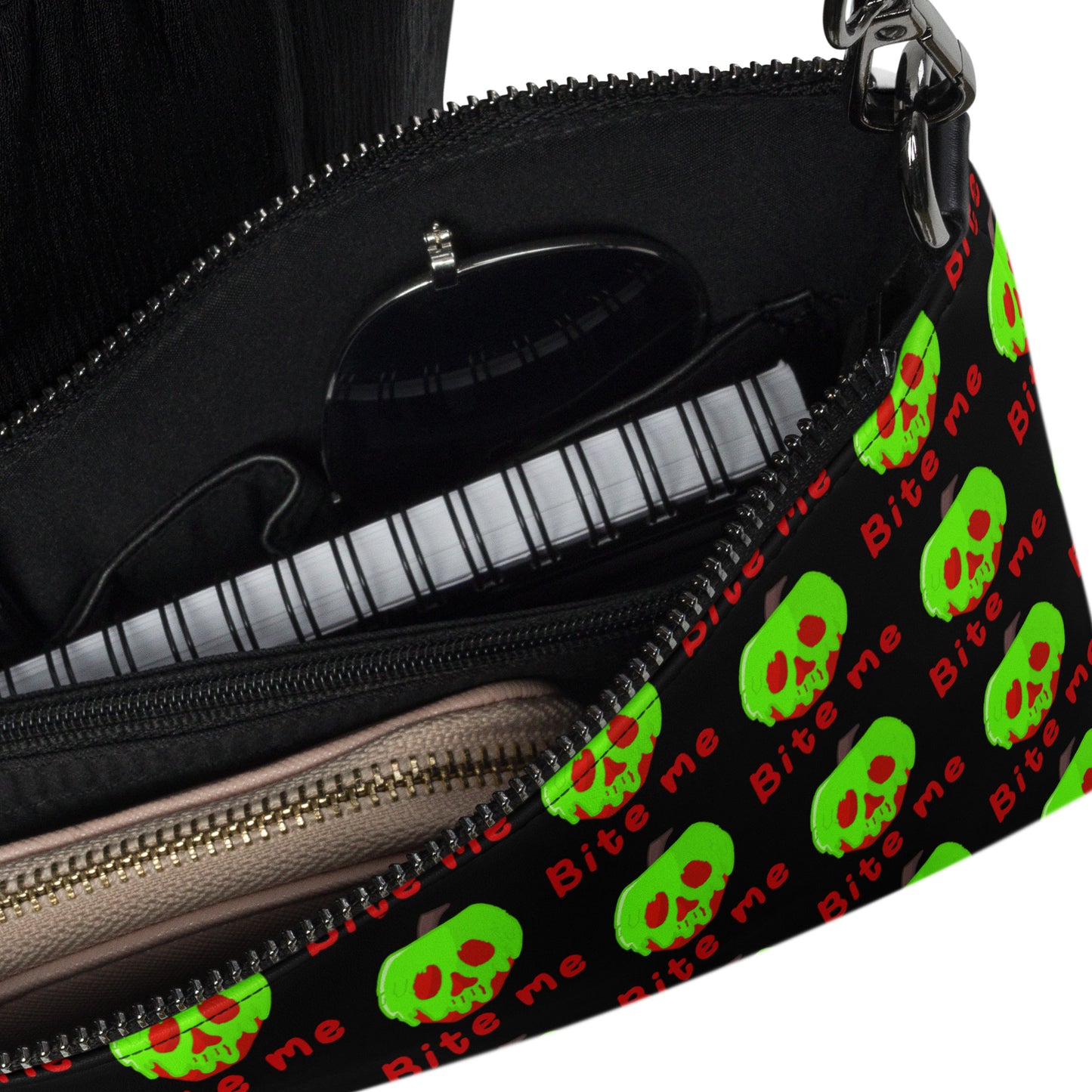 This black crossbody purse features a large red apple dipped in green poison with the words Bite Me underneath and the back is a small size in a patterned print.