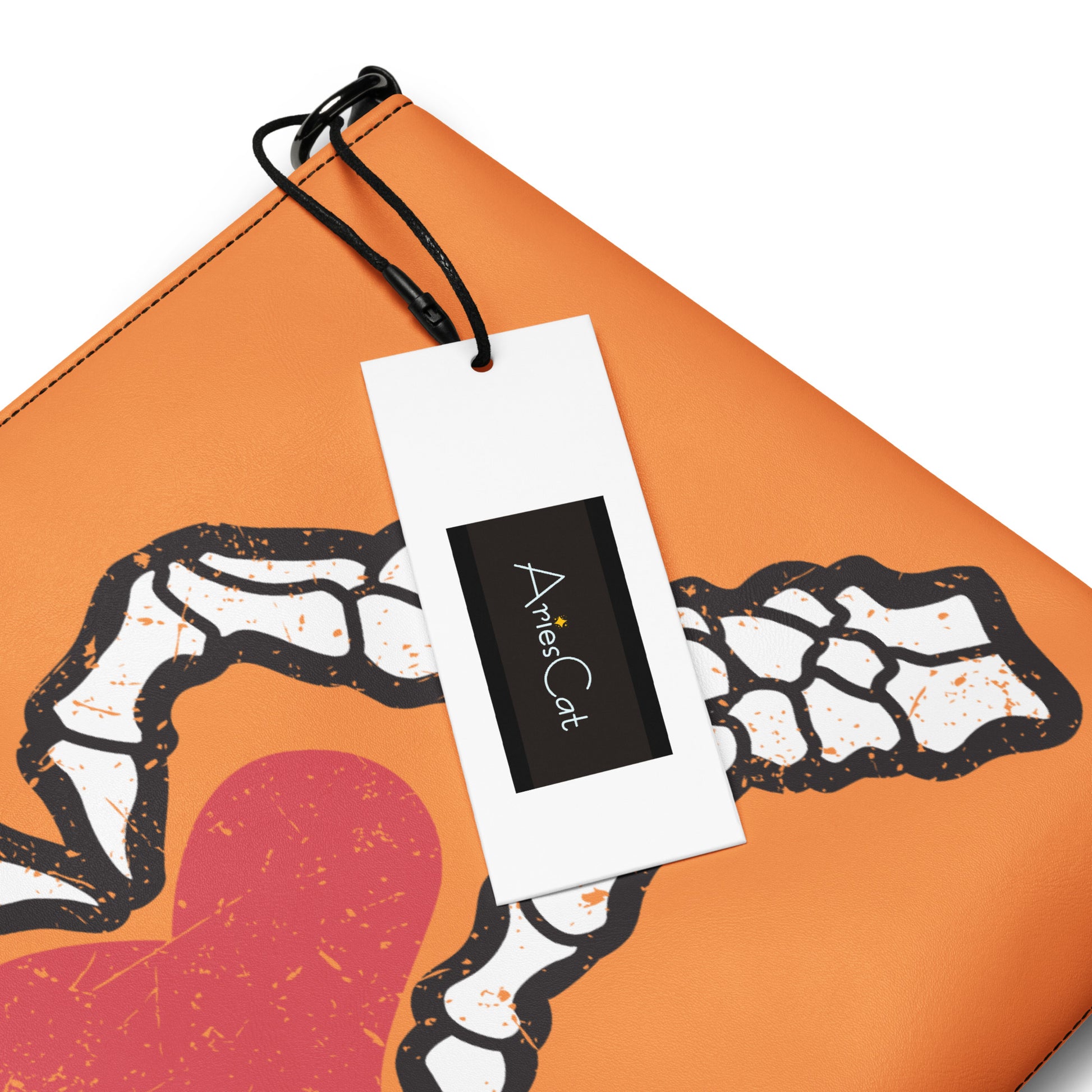 This orange crossbody purse converts to a large wristlet clutch. It features a distressed print of skeleton hands forming a heart with a red heart inside. One side the design is large and the other is a smaller patterned print.