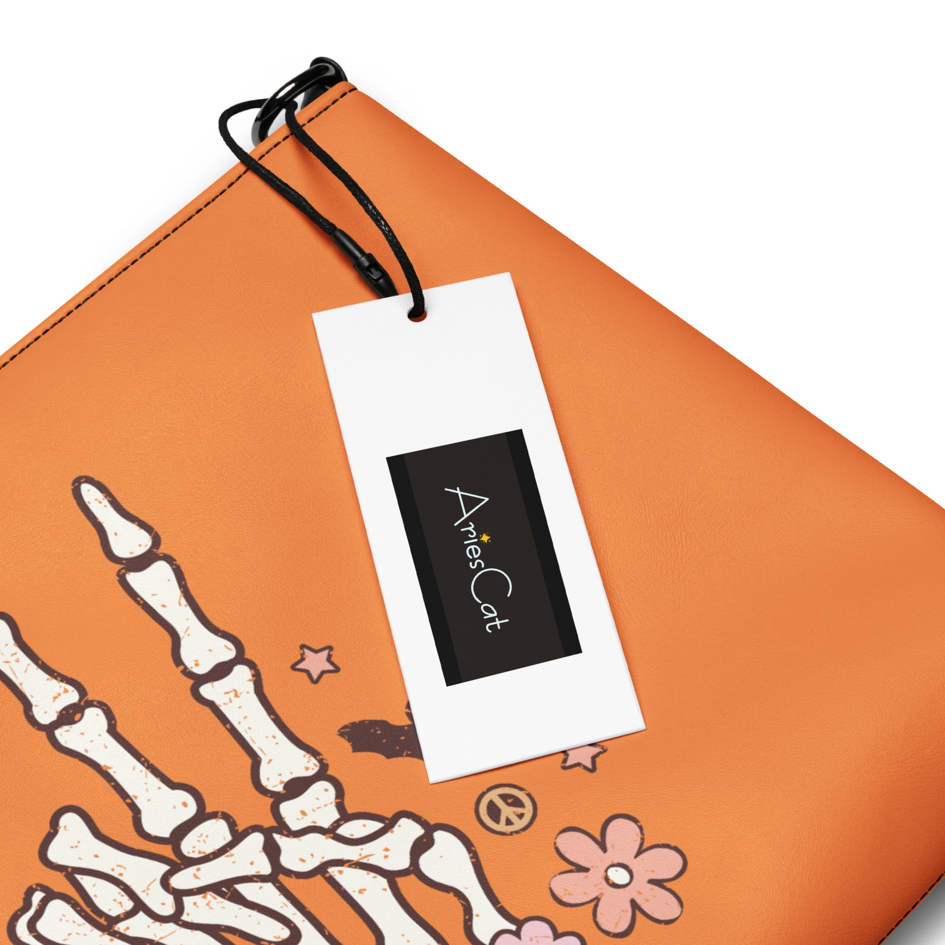 This orange crossbody purse features a skeleton hand making a peace sign surrounded by bats, flowers and peace signs.