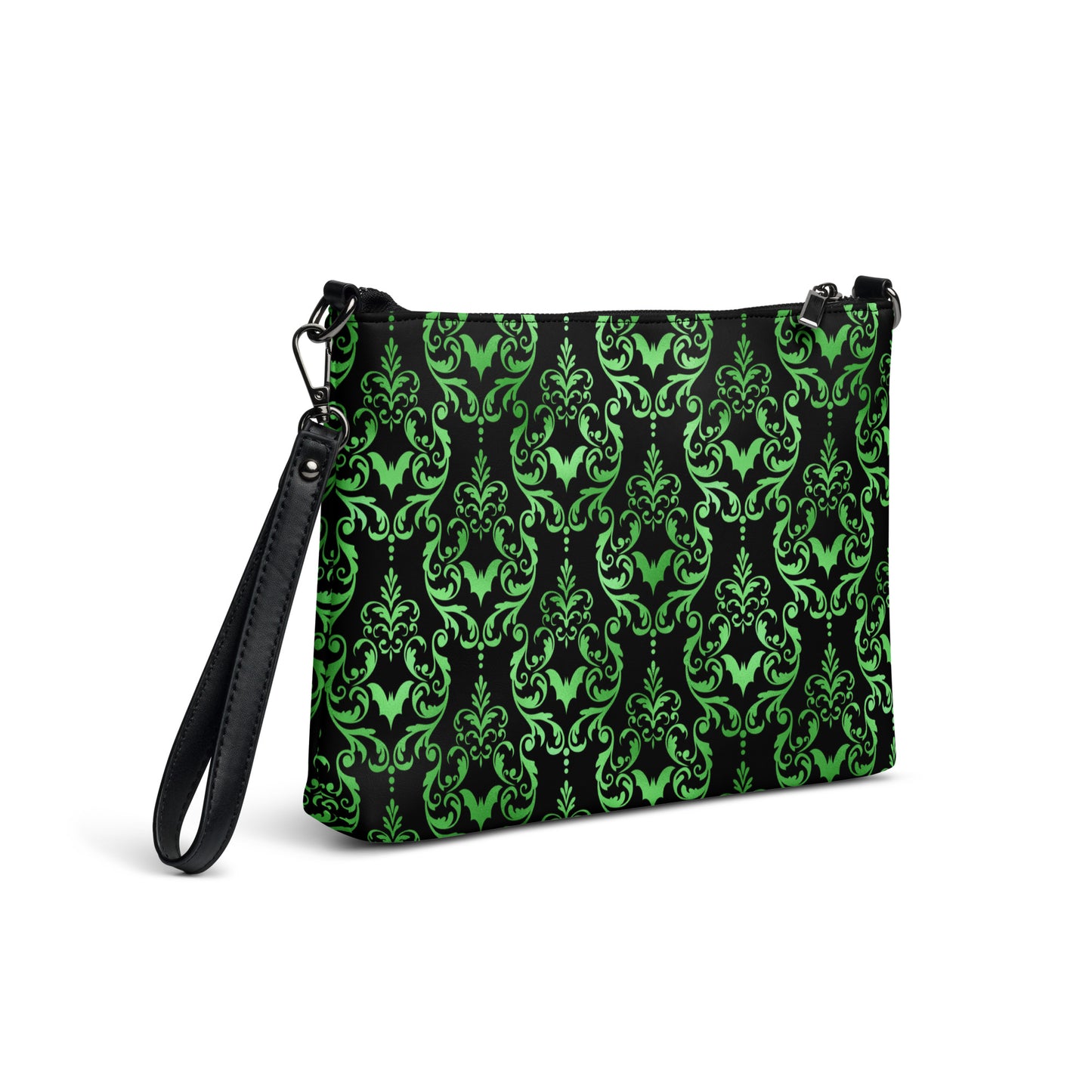 This black crossbody shoulder bag converts into a large wristlet clutch features a retro wallpaper print of green bats and swirls.