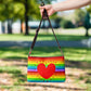 This shoulder crossbody purse converts to a large wristlet clutch. It features horizontal rainbow stripes with a large red heart in the center.