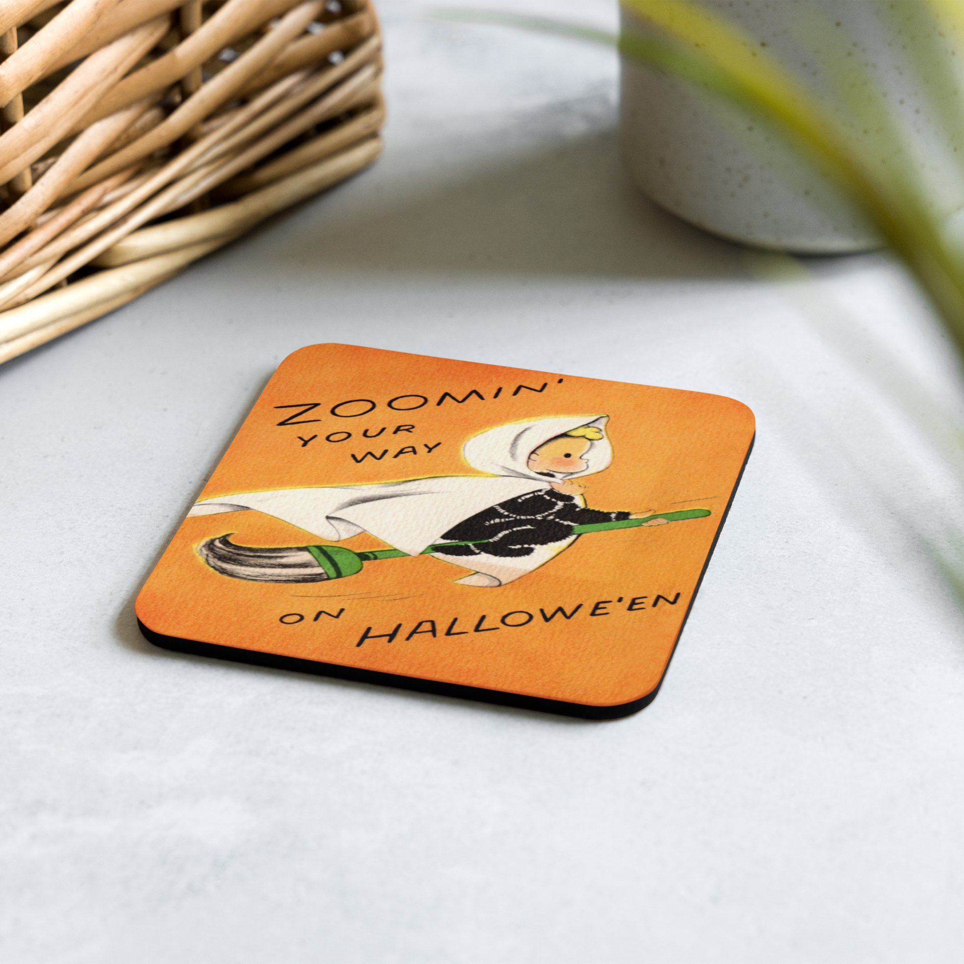 This orange glossy cork back coaster features a retro Halloween illustration that says Zoomin' Your Way On Halloween with an adorable witch flying on a broomstick.