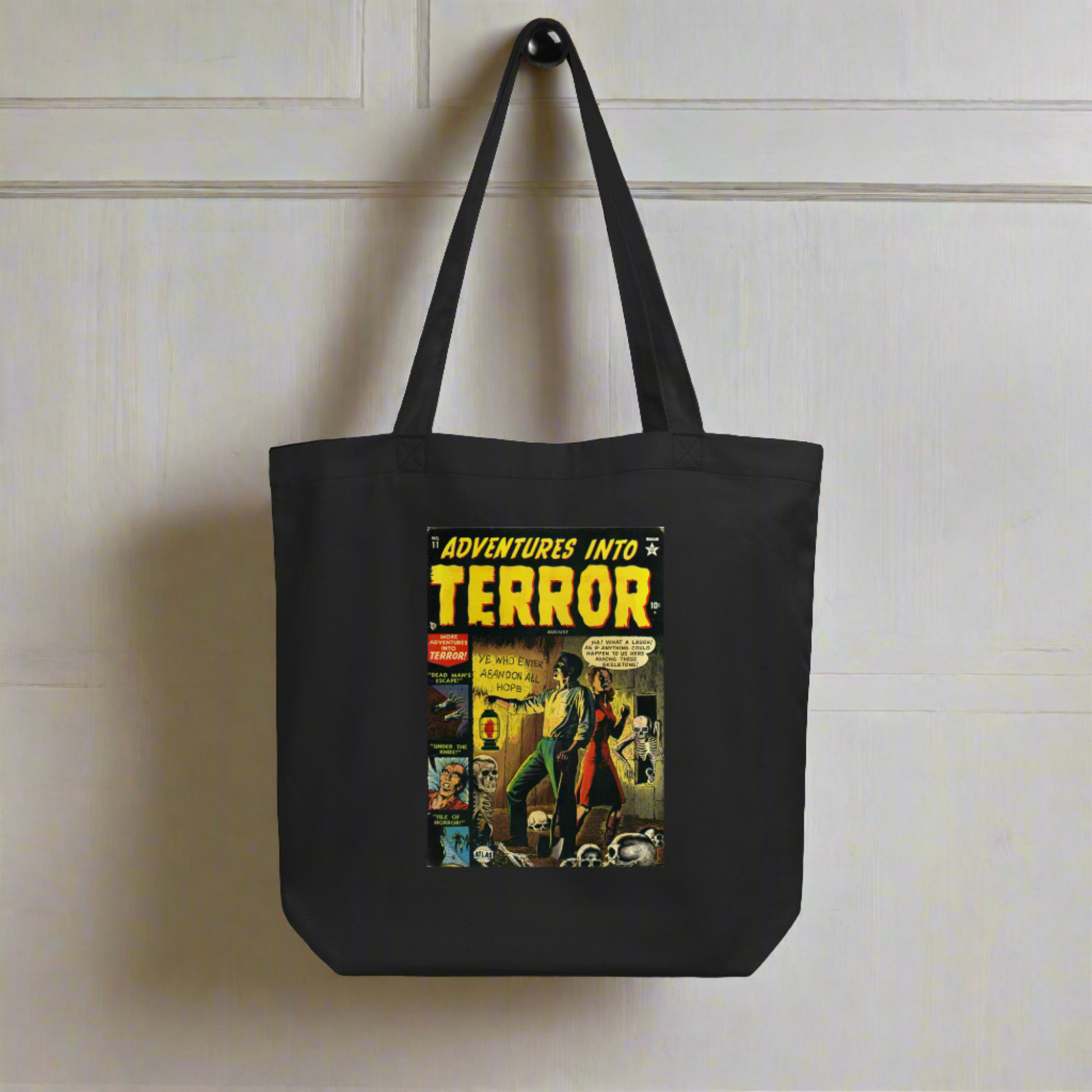 This largo eco cotton black tote bag features a vintage comic book cover titled Adventures Into Terror. It features a couple with a lantern surrounded by skeletons.