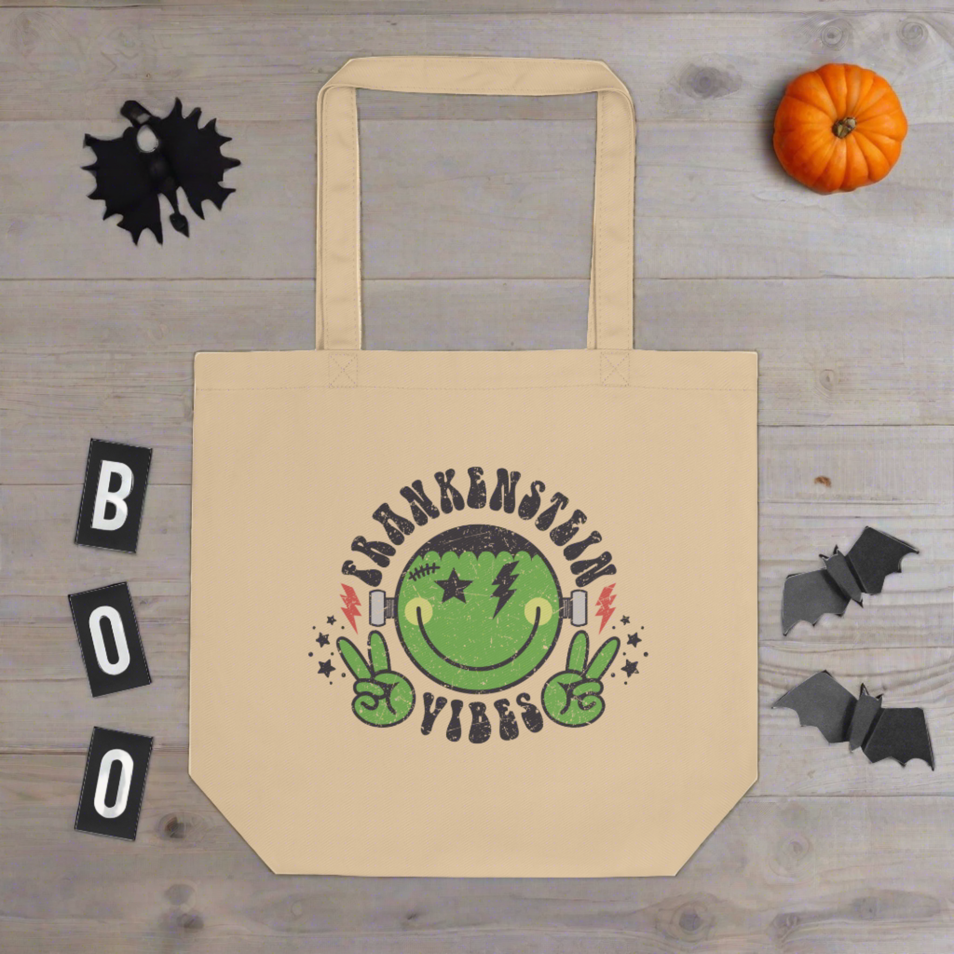 This large eco cotton tote features a distressed retro style design of Frankenstein's Monster. He's smiling and making the peace sign. The lettering Frankenstein Vibes is around his head with little stars.