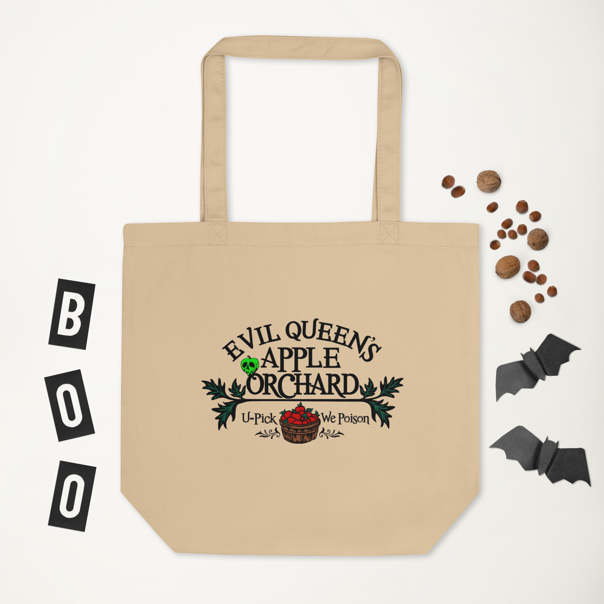 This tote bag says Evil Queen's Apple Orchard U-Pick We Poison and there is a basket of red apples with a poisoned green apple on the O in Orchard.