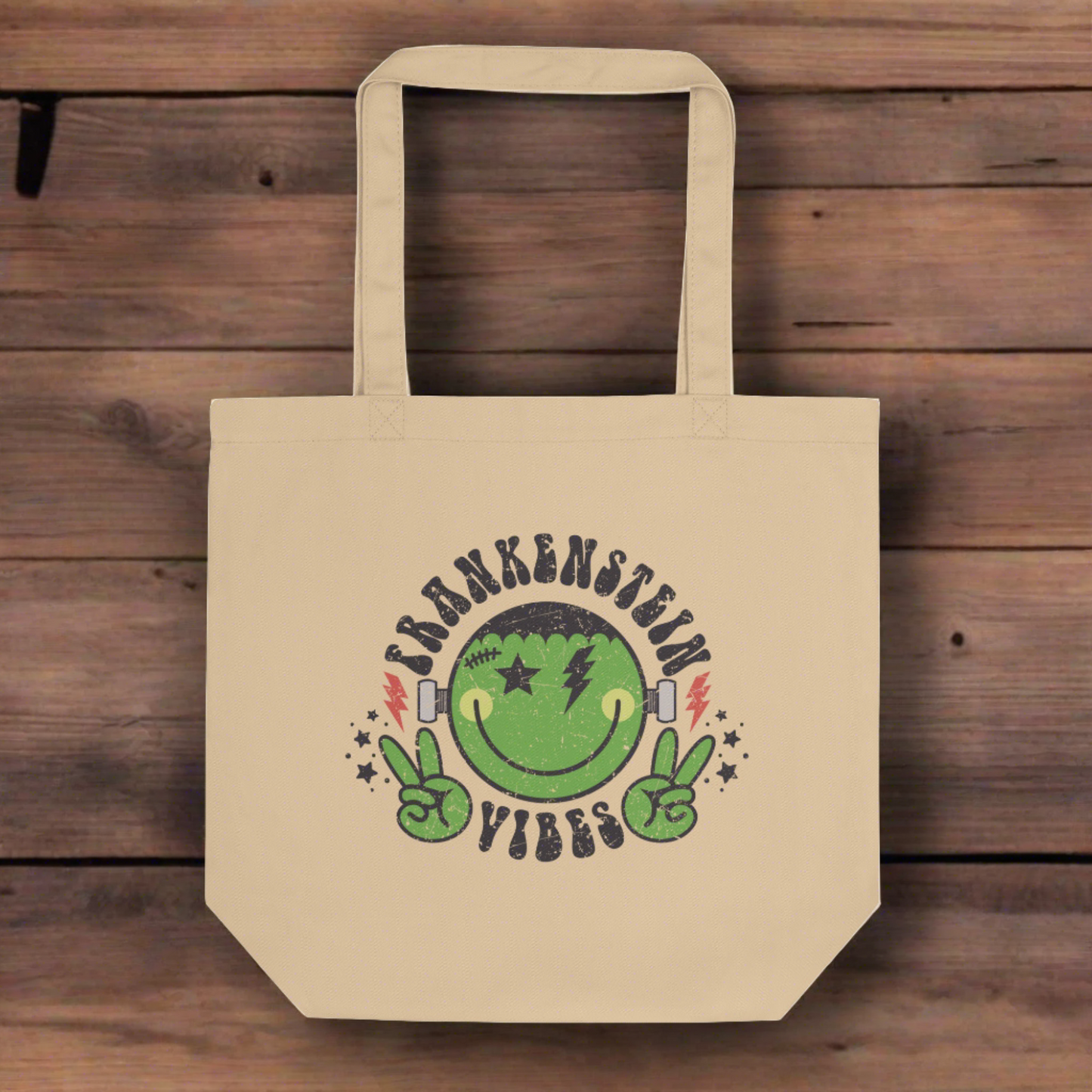 This large eco cotton tote features a distressed retro style design of Frankenstein's Monster. He's smiling and making the peace sign. The lettering Frankenstein Vibes is around his head with little stars.