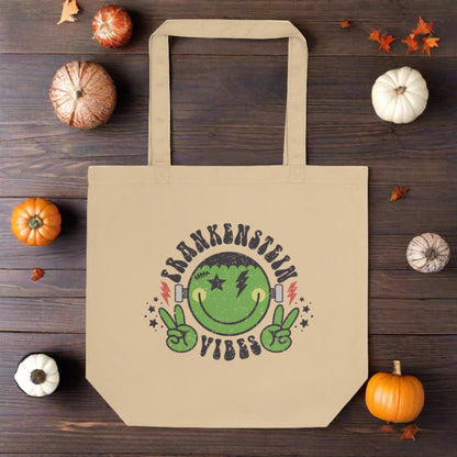 This large eco cotton tote features a distressed retro style design of Frankenstein's Monster. He's smiling and making the peace sign. The lettering Frankenstein Vibes is around his head with little stars.