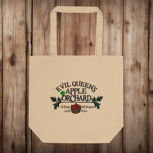 This tote bag says Evil Queen's Apple Orchard U-Pick We Poison and there is a basket of red apples with a poisoned green apple on the O in Orchard.