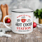 This hot chocolate camping enamel mug features a cute design that says Warm Up At The Hot Cocoa Station Served Fresh Daily.