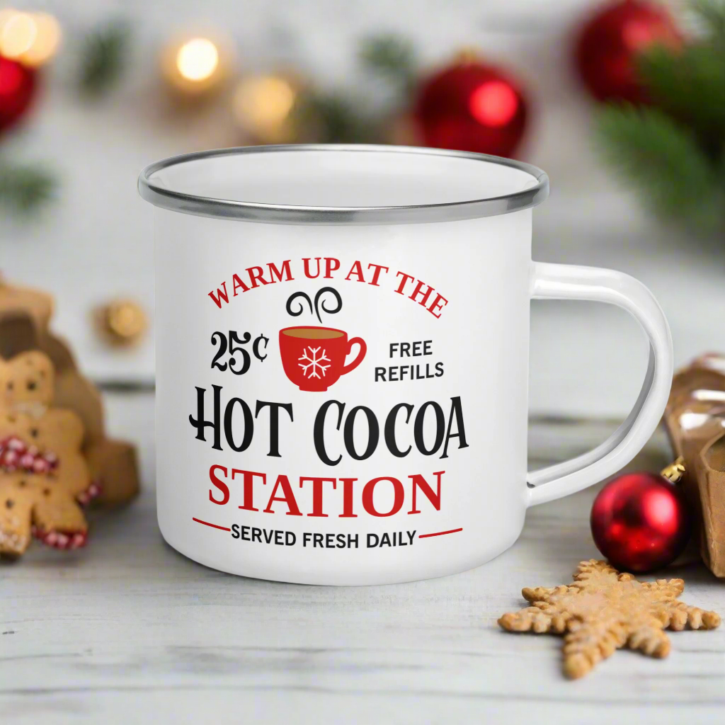 This hot chocolate camping enamel mug features a cute design that says Warm Up At The Hot Cocoa Station Served Fresh Daily.