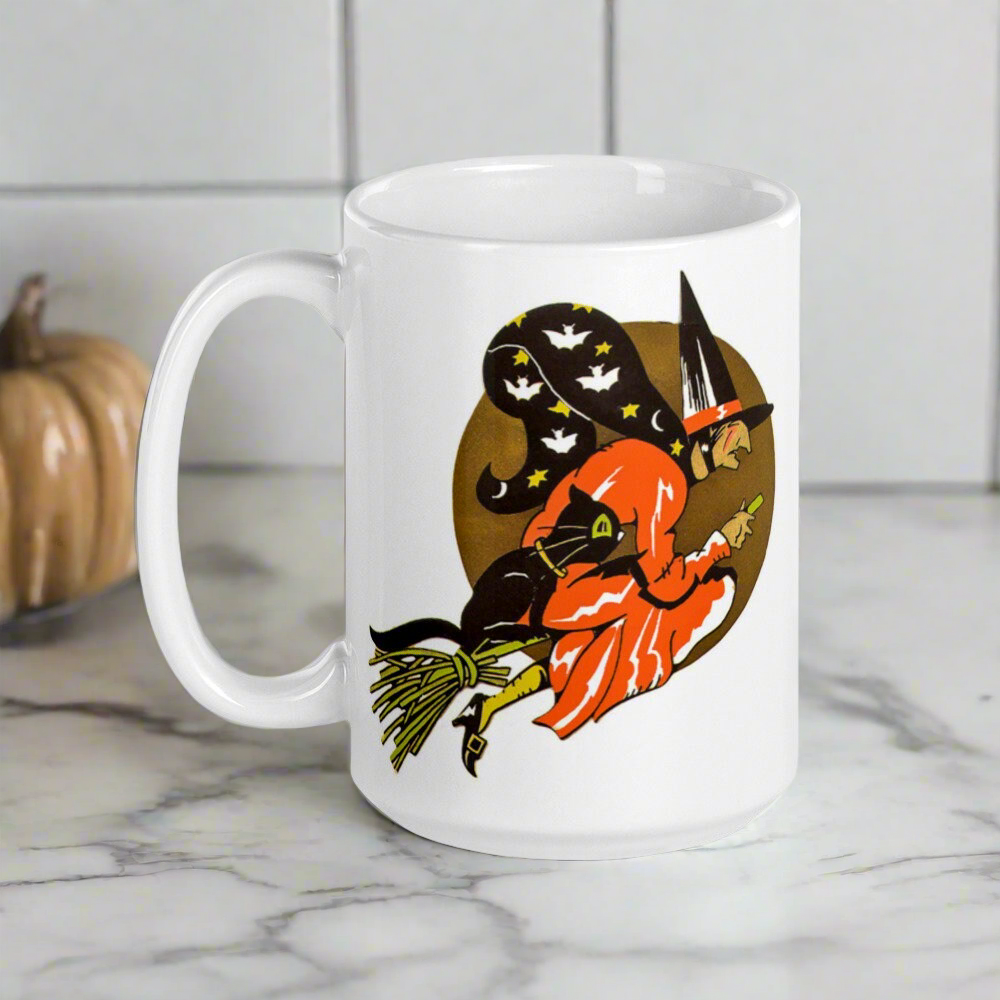 This ceramic glossy coffee mug features a retro vintage Halloween print of a witch flying on her broom with her black cat and a gold moon in the background.