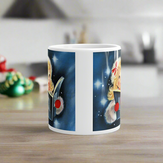 This ceramic glossy coffee mug features a midcentury retro Christmas illustration of a young blond girl singing wearing a white fluffy jacket and hat. She is wearing red mittens and holding a book that says Noel. The background is blue with stars.