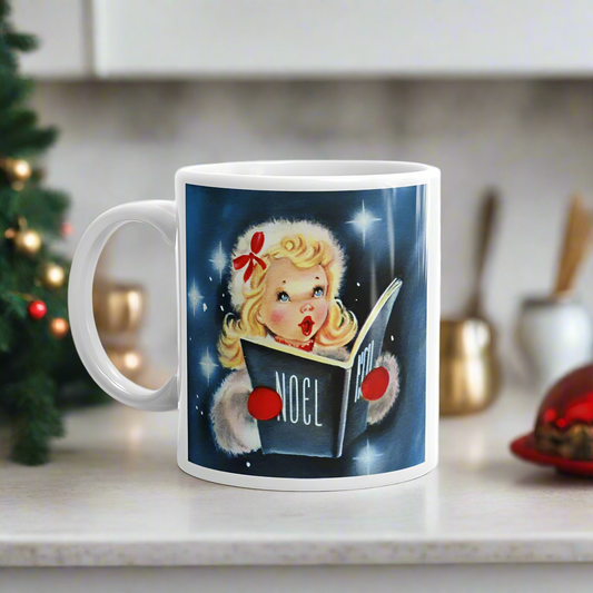 This ceramic glossy coffee mug features a midcentury retro Christmas illustration of a young blond girl singing wearing a white fluffy jacket and hat. She is wearing red mittens and holding a book that says Noel. The background is blue with stars.