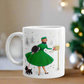 This ceramic glossy coffee mug features a midcentury retro Christmas illustration of a woman dressed in a green dress with a green hat, a black muff and red and white striped glove. She is walking her little black scottie and reaching into her mailbox. 