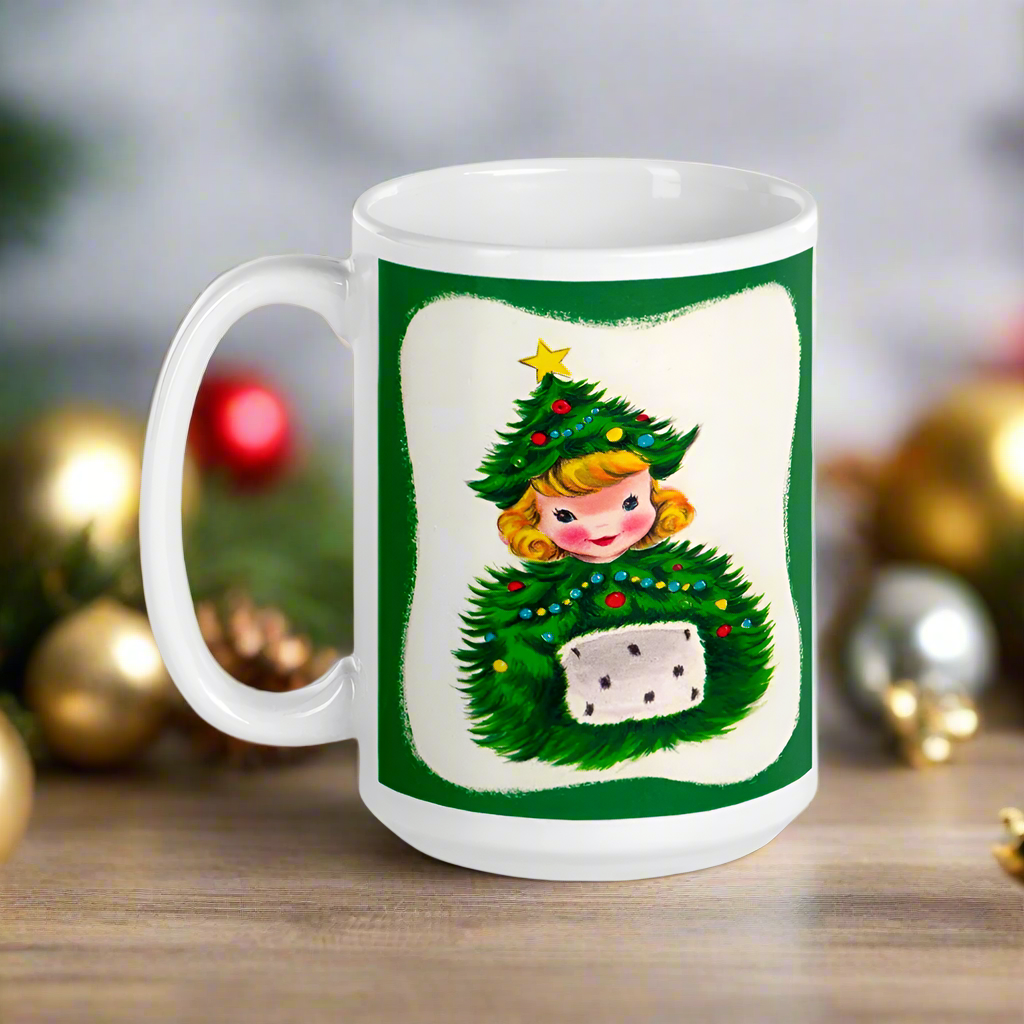 This ceramic glossy coffee mug features a blond girl wearing a christmas tree hat and coat. The hat is adorned with a yellow star on top. She is also wearing a white and green muff.