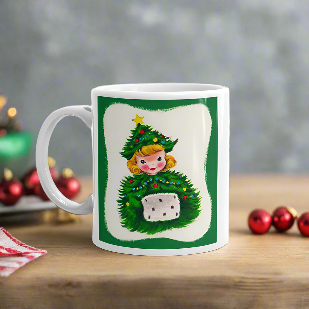 This ceramic glossy coffee mug features a blond girl wearing a christmas tree hat and coat. The hat is adorned with a yellow star on top. She is also wearing a white and green muff.