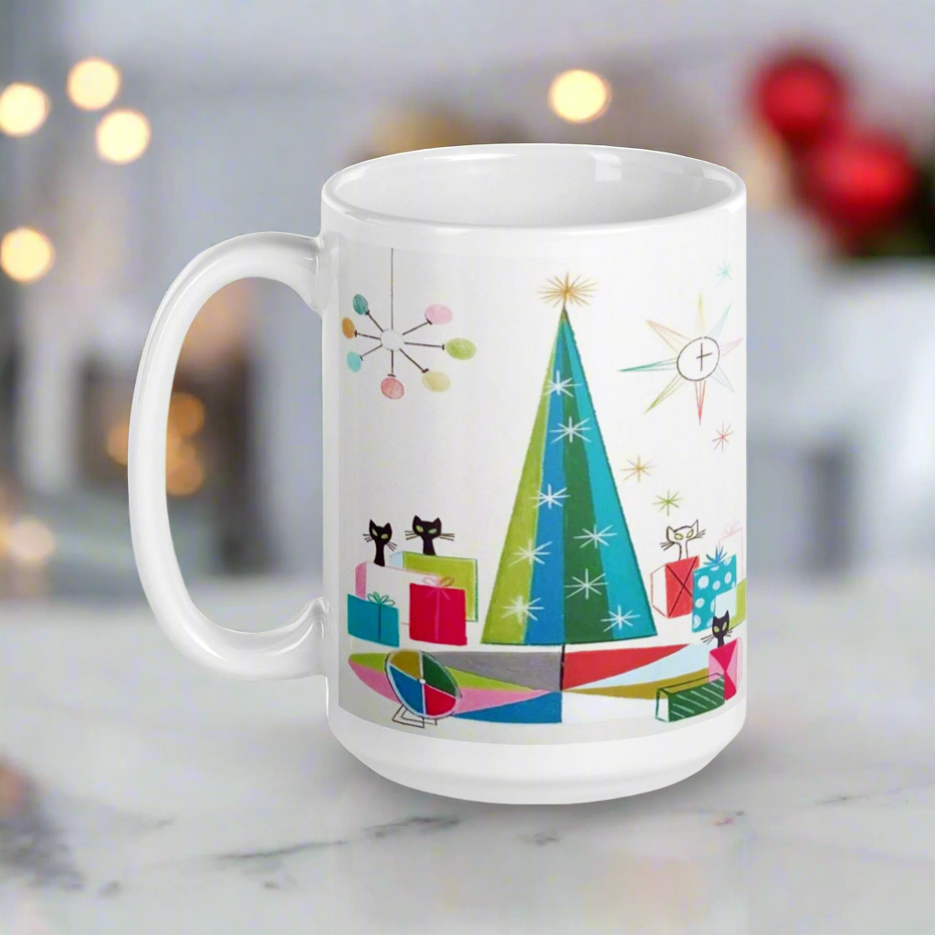 This ceramic glossy Christmas coffee mug features an atomic Midcentury illustration of cats peeking out from behind presents around a Christmas tree. There is a colorful round rug, light projector, clock and chandelier all in atomic era style.