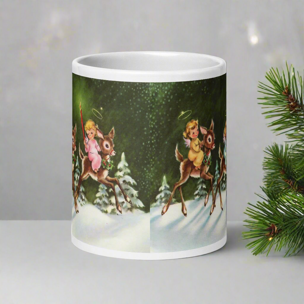 This ceramic glossy mug features three young angels riding reindeer in the snow.