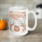 This glossy ceramic coffee mug features a retro vintage Halloween illustration that says Halloween with trees with spooky cute faces and orange leaves, with a jack o lantern in the middle and a black cat sleeping on the pumpkin.