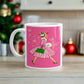 This ceramic glossy mug features a vintage Christmas illustration of a retro Midcentury housewife dressed in a pink and white striped dress with a green purse and heels. The background is pink and there are snowflakes. 