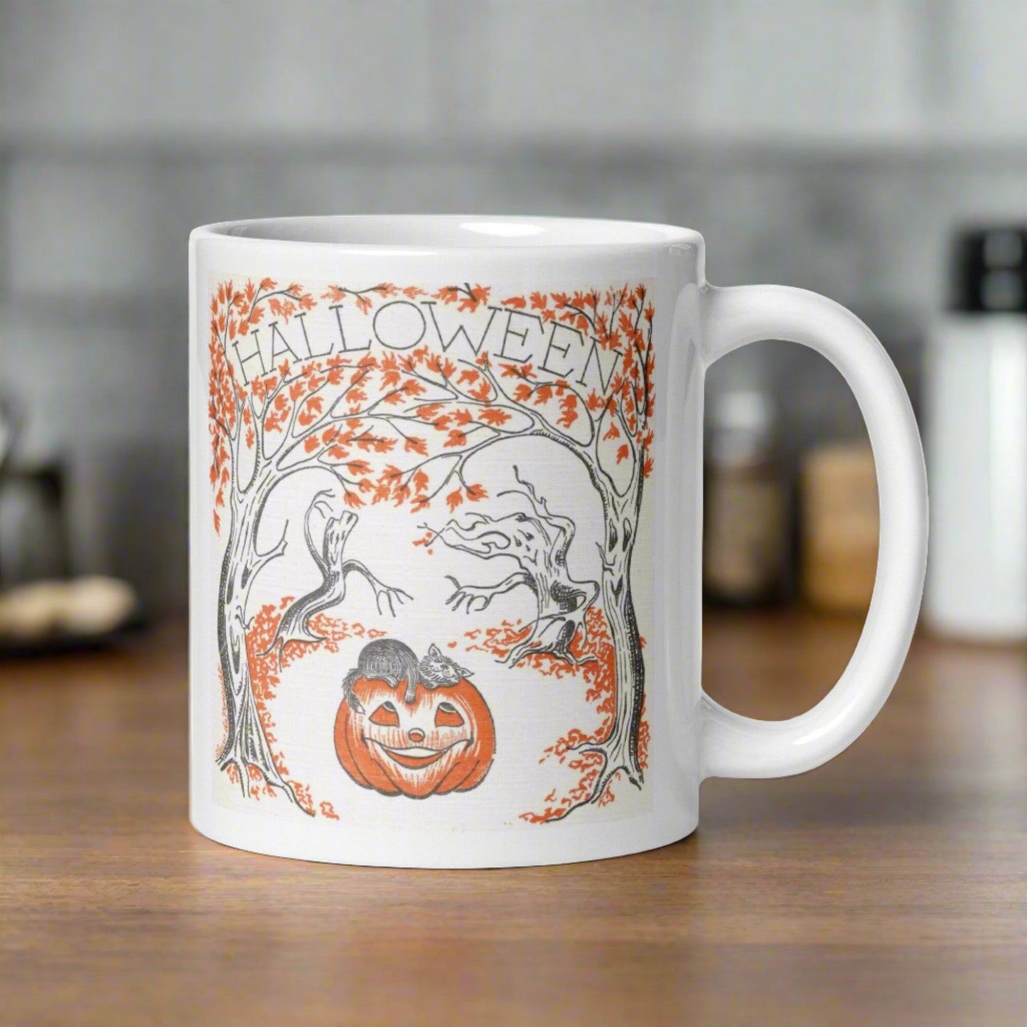 This glossy ceramic coffee mug features a retro vintage Halloween illustration that says Halloween with trees with spooky cute faces and orange leaves, with a jack o lantern in the middle and a black cat sleeping on the pumpkin.