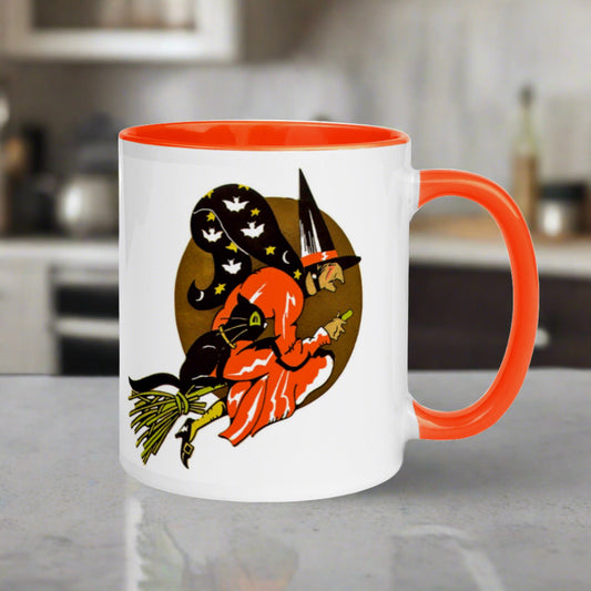 This Halloween mug features a vintage print of a witch flying on her broom with her black cat and a gold moon in the background. The witch's cape has bats and stars.