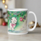 This ceramic glossy coffee mug features a midcentury vintage Christmas Illustration that says It's Christmas! There is an adorable white kitten wearing a pink bow underneath the christmas tree.