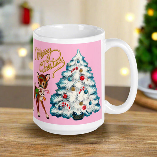 This ceramic glossy mug has a Mid Century retro Christmas print of an adorable deer with a candy cane in mouth and white christmas tree outlined in teal. The words Merry Christmas are gold and there is a pink background of the whole design.