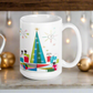 This ceramic glossy Christmas coffee mug features an atomic Midcentury illustration of cats peeking out from behind presents around a Christmas tree. There is a colorful round rug, light projector, clock and chandelier all in atomic era style.