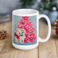 This glossy ceramic coffee cup features an adorable vintage retro print of a white christmas kitten with a blue ornament in her mouth. She is wearing a pink bow and is sitting next to a pink Christmas tree with a blue background.