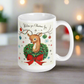 This ceramic glossy coffee mug is a midcentury christmas illustration that says Wishing you Christmas Joy. It features a reindeer with her tongue out wearing a Christmas wreath with a red bow. Her antlers are decorated with tinsel and  ornaments.